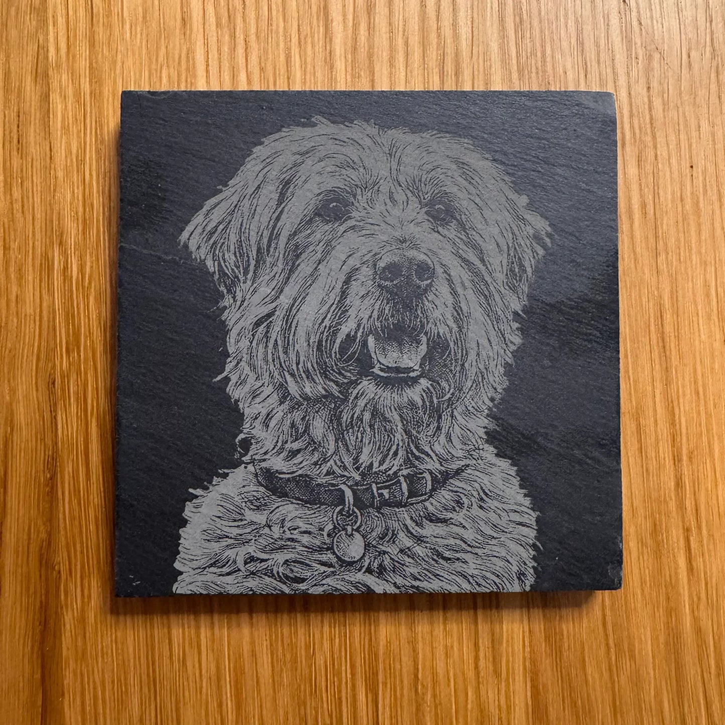 Slate coaster with engraved fluffy dog portrait, perfect for pet lovers