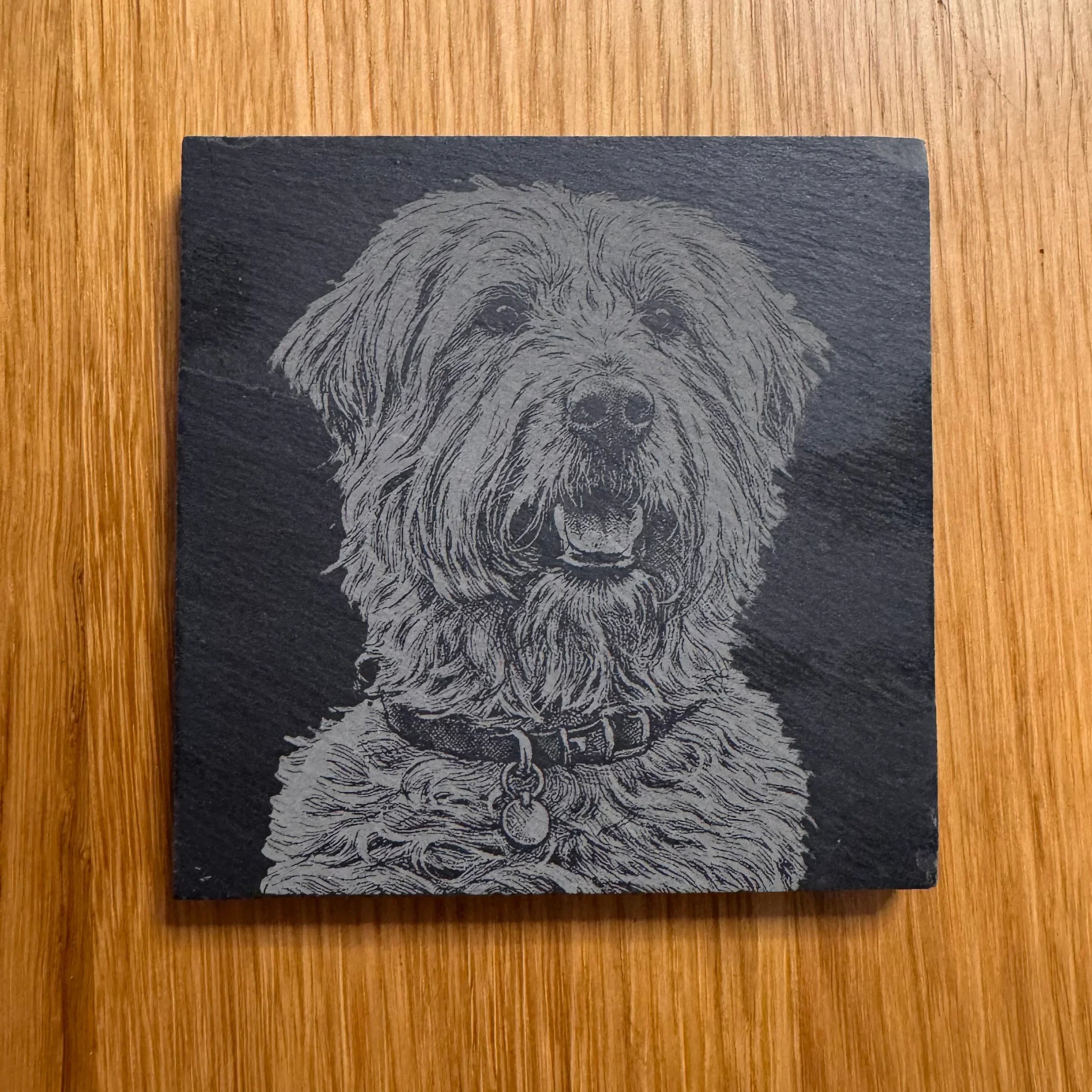 Slate coaster with engraved fluffy dog portrait, perfect for pet lovers